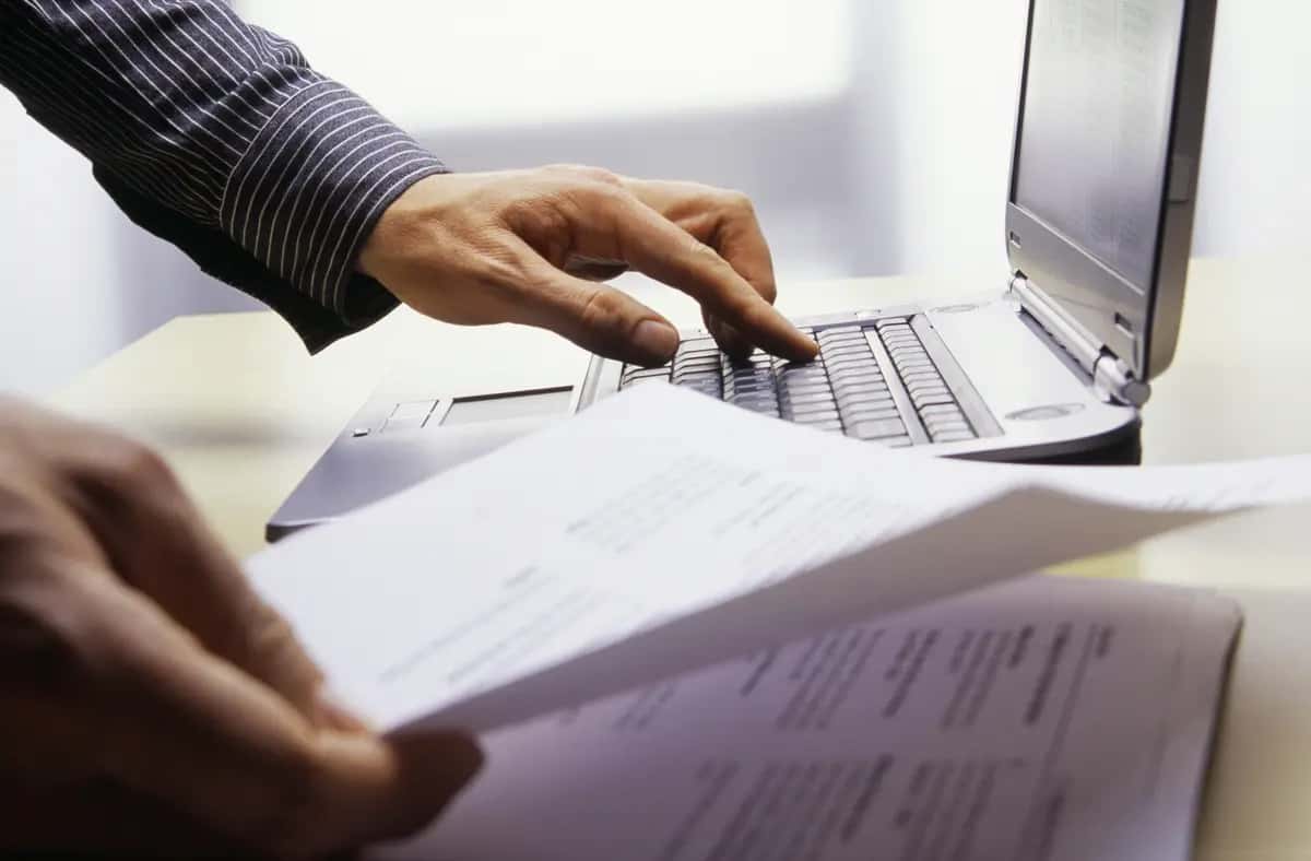 businessman-looking-at-papers-while-using-laptop-2026-01-11-09-55-02-utc (1).jpg